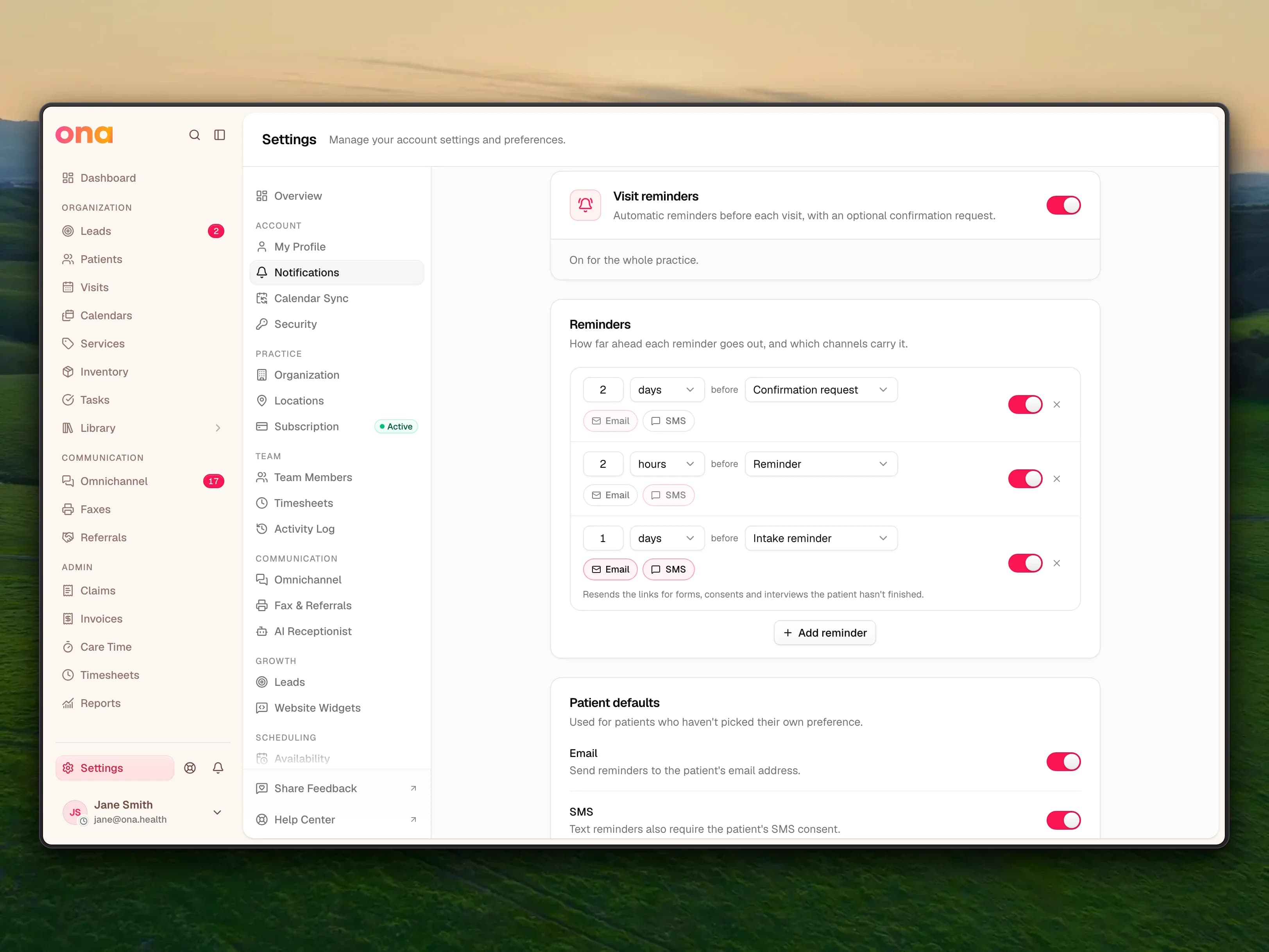 The Notifications settings page with Visit reminders switched on and three reminder rules: an email Confirmation request two days before, an SMS Reminder two hours before and an Intake reminder by email and SMS one day before, above Patient defaults with email and SMS reminders on.